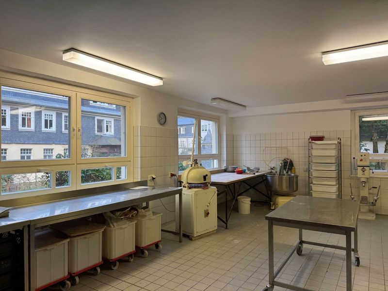 Helle Backstube mit Edelstahltischen, Teigteilmaschine und Knetmaschine