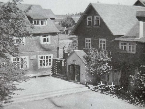 Historische Aufnahme: Hof zwischen Schieferhäusern mit steilen Dächern und kleinem Anbau