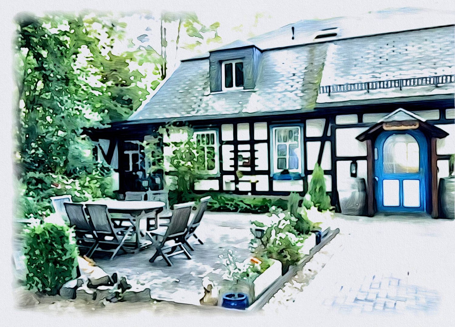 Gemaltes Fachwerkhaus mit Gaube im Schieferdach und blauer Rundbogentür, davor eine Terrasse mit Tisch und Stühlen